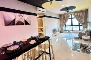 Ein modernes Wohnzimmer mit Essbereich, großen Fenstern und Deckenventilator.