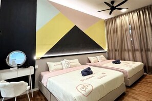 Ein Hotelzimmer mit zwei Betten, einem Schreibtisch mit Spiegel und einem Deckenventilator.