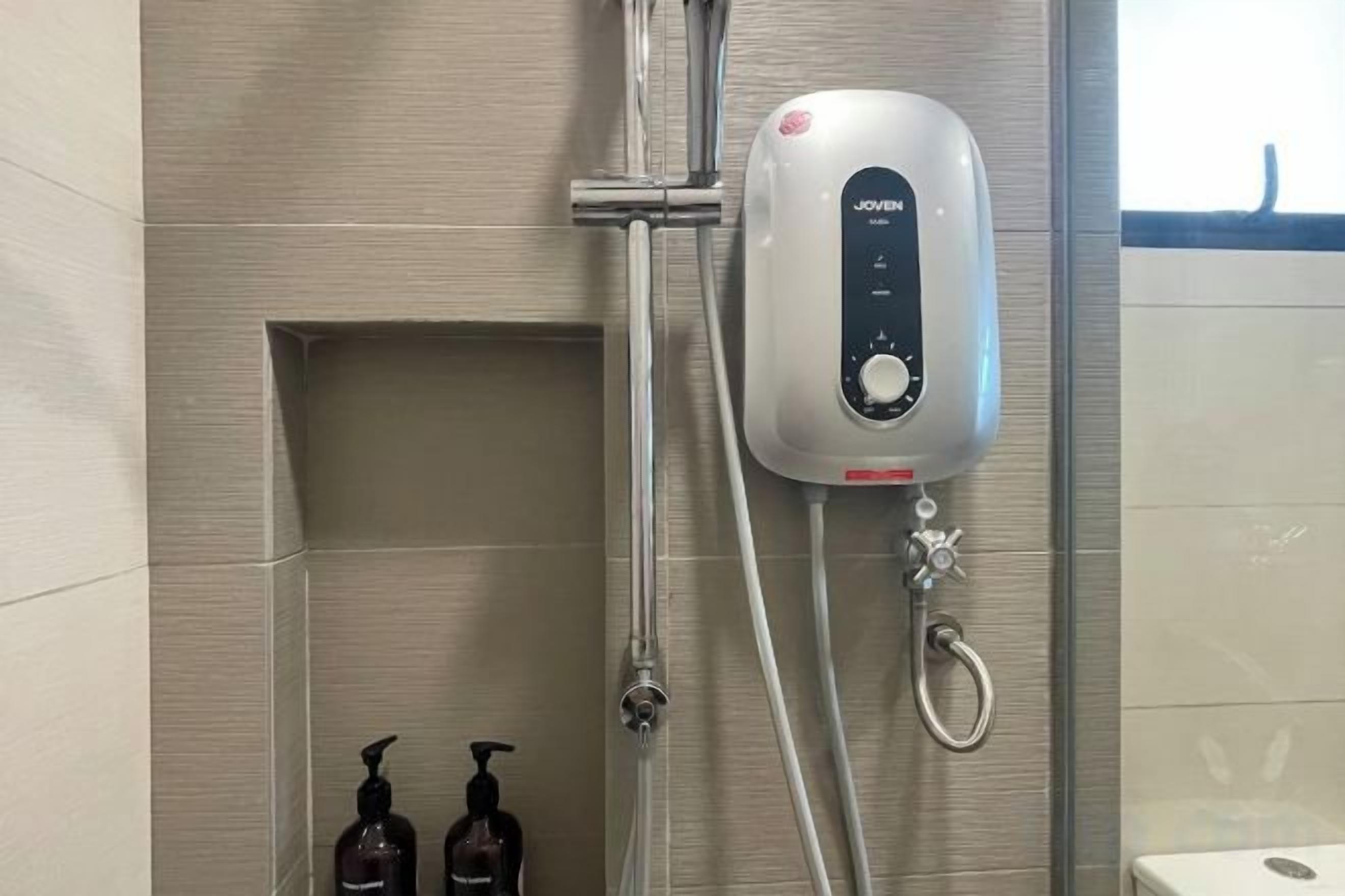 Une douche équipée d’un panneau de commande, de deux savons et d’un porte-serviettes.