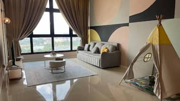 A modern living room with a sofa, a round coffee table, a tent-like structure, and a large window with curtains.