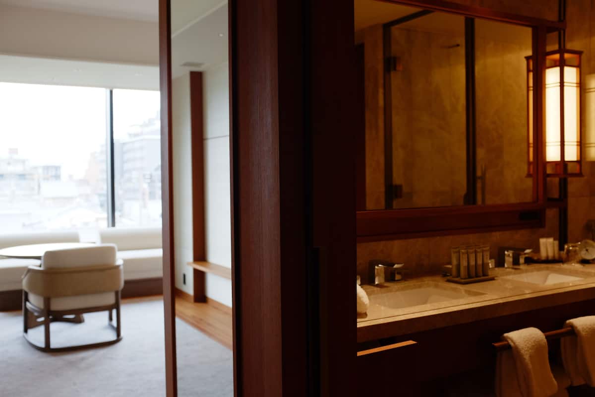 A modern bathroom with a large mirror, a bathtub, and a vanity with a sink.