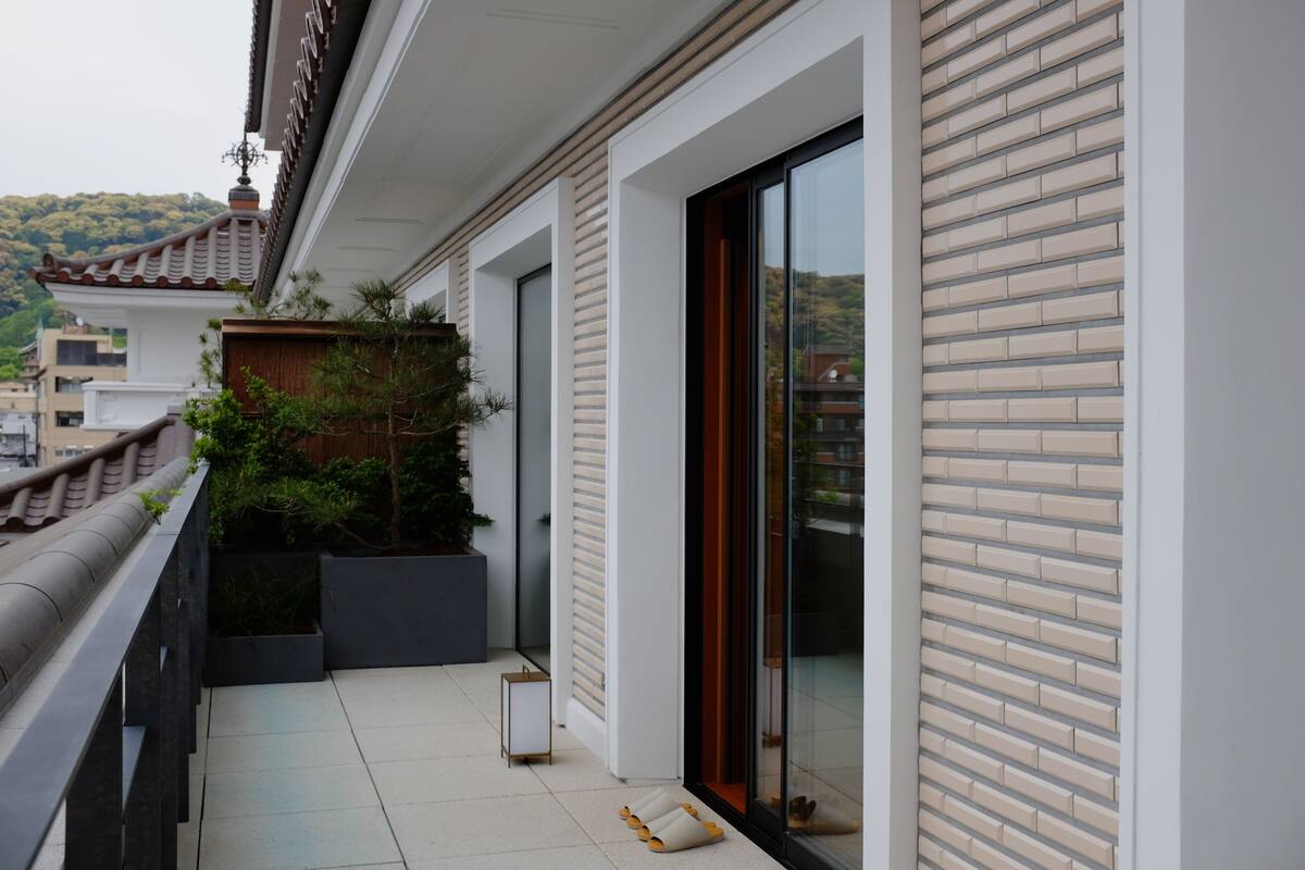 A balcony with a modern design, a potted plant, and a sliding glass door.