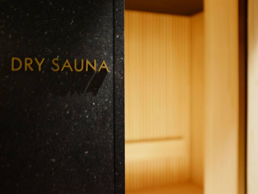 Parede preta com a inscrição 'DRY SAUNA' em letras douradas.