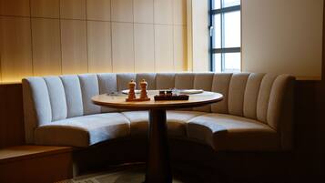 A modern room with a curved sofa, a round table, and a large window.