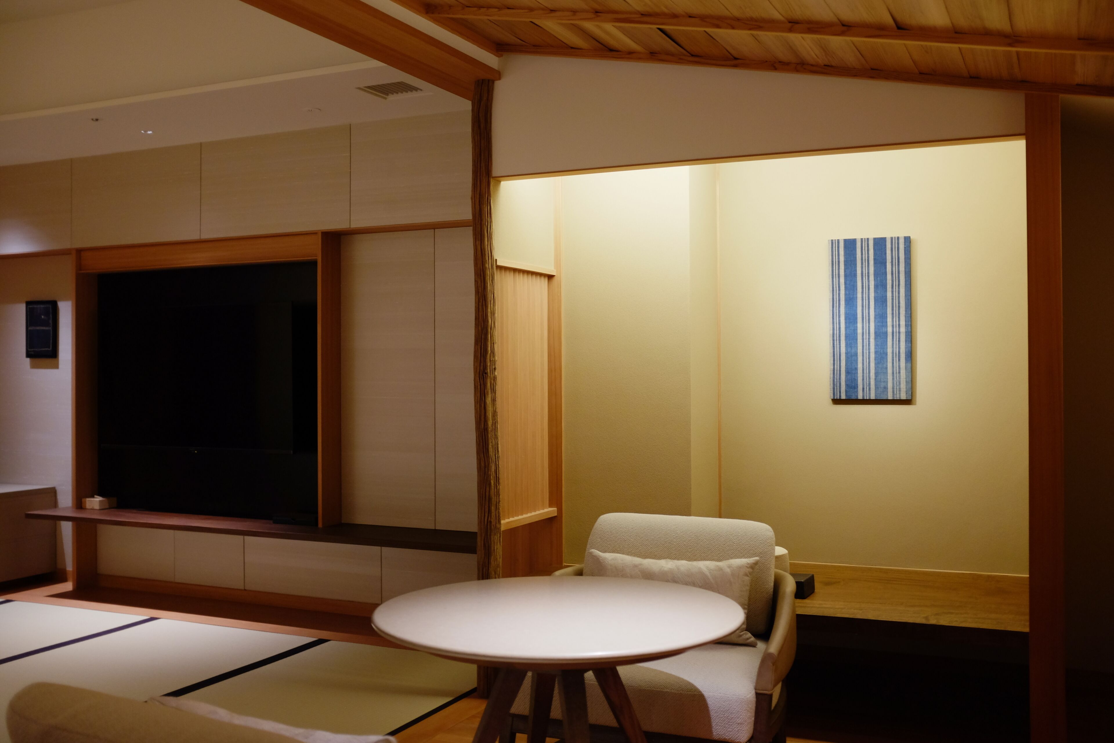 A traditional Japanese room with tatami flooring, a low table, and a sofa.