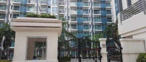 A gated entrance to a modern apartment building with a central courtyard.
