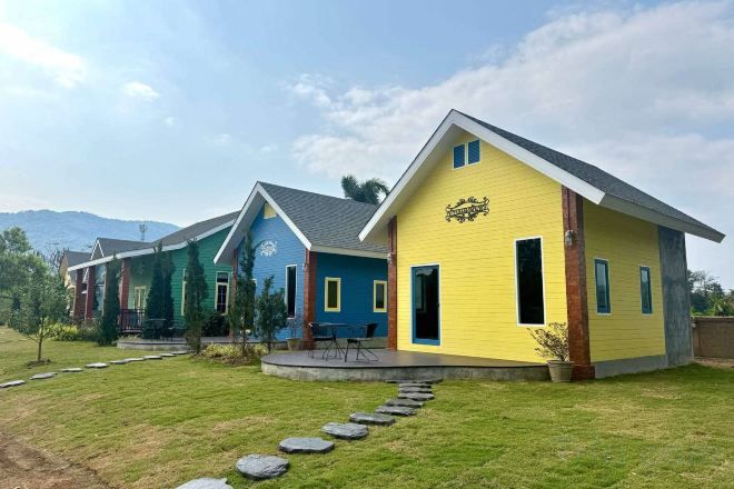 A row of colorful houses with a grassy lawn and a stone pathway.