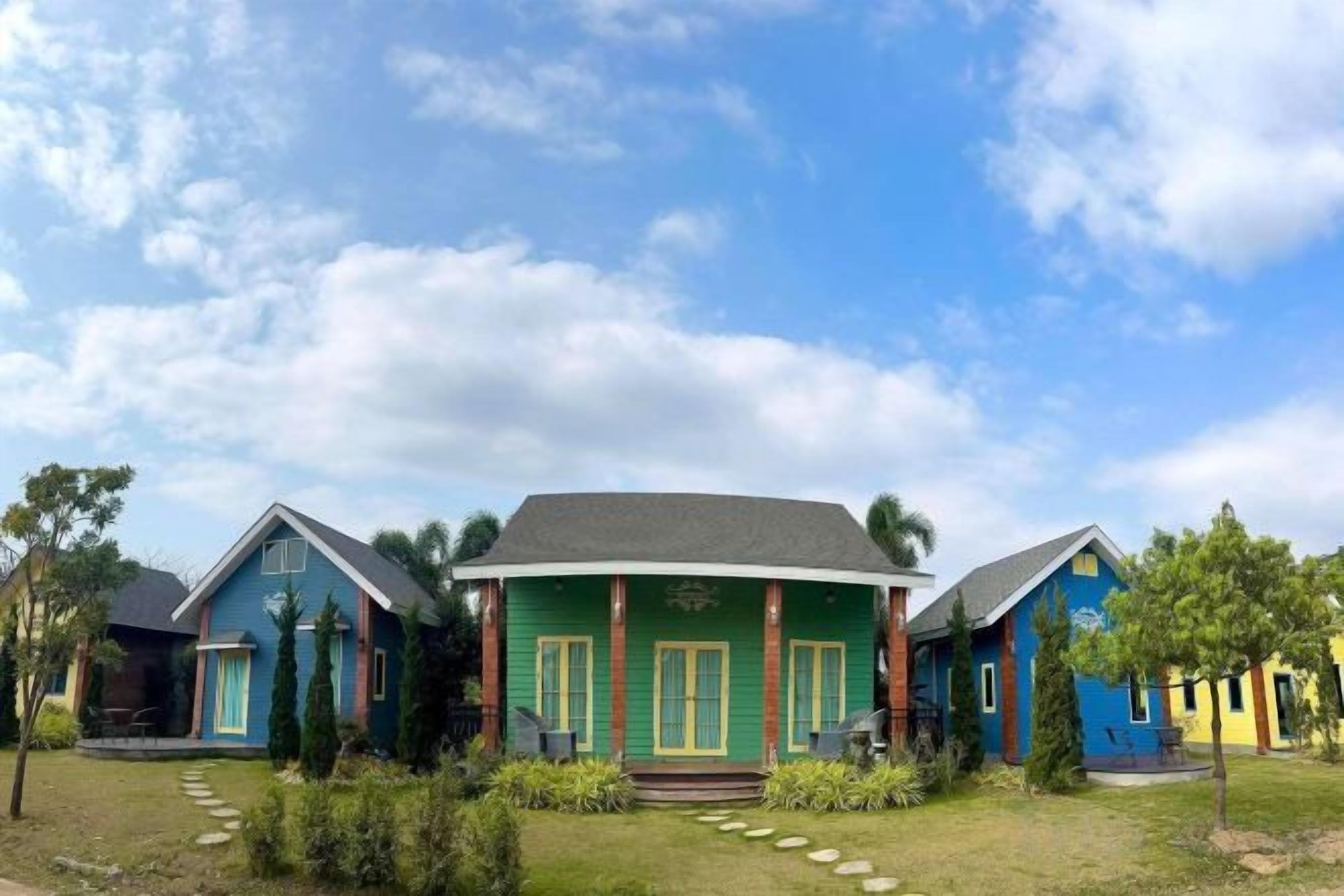 A row of houses with a grassy lawn and a clear sky.