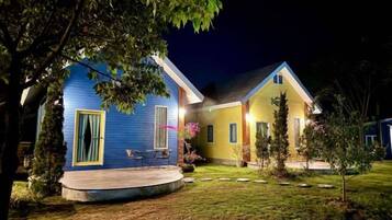 A two-story house with a porch and a small garden.