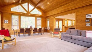 A wooden interior with a dining area, a sofa, and a fan. - Mountain Lodge w/ Hot Tub + Private River Beach (Leavenworth)