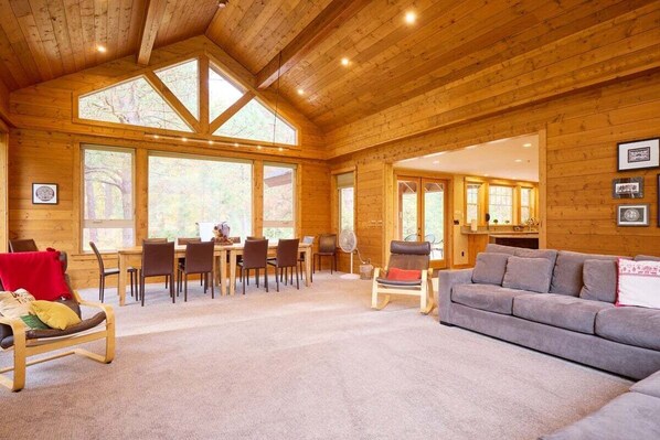 Ein Holzinterieur mit Essbereich, einer Couch und einem Ventilator.