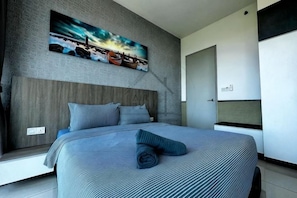 A modern bedroom with a large bed, a headboard, and a painting on the wall.