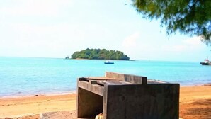 A beach with a concrete structure, calm water, and a distant island. - PD D’Wharf Seaview & Sunset Suite (up to 6 Pax) (Port Dickson)
