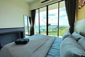 A hotel room with a large window, a bed, and a view of a bridge and greenery. - PD D’Wharf Seaview & Sunset Suite (up to 6 Pax) (Port Dickson)