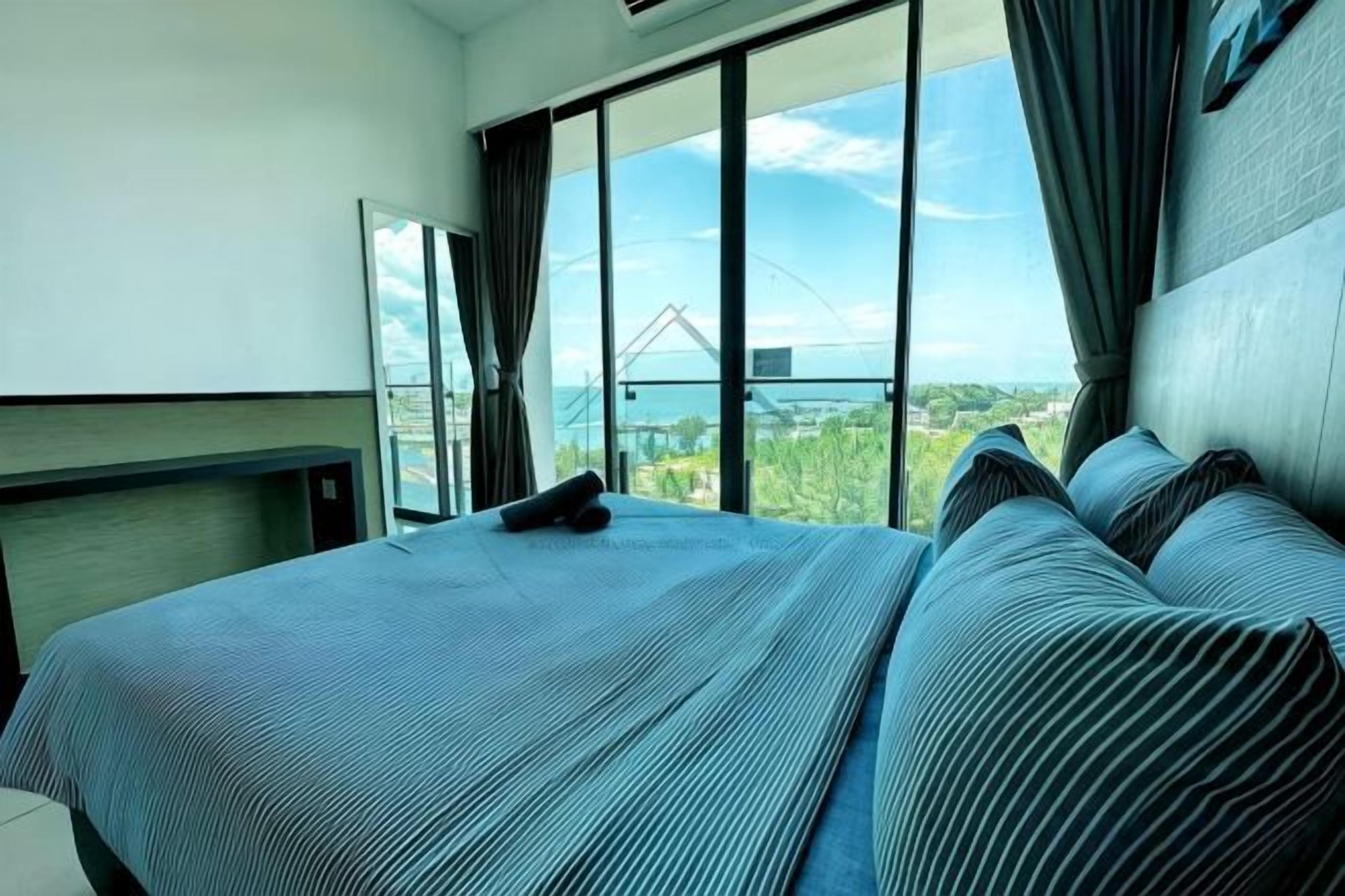 A hotel room with a large bed, a view of a bridge, and a balcony.