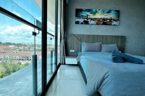 Ein Schlafzimmer mit großem Fenster, einem Bett und einem Bild an der Wand.