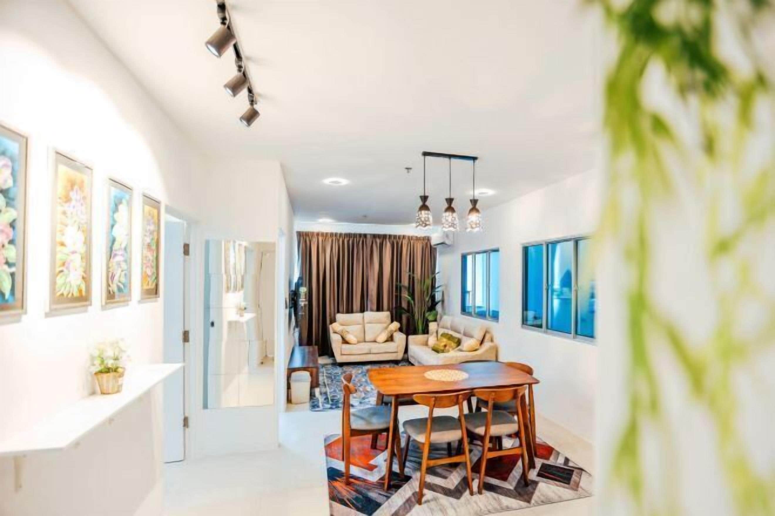 A modern living room with a dining area, a sofa set, and artwork on the walls.