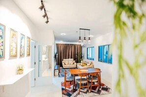 A modern living room with a dining area, a sofa set, and artwork on the walls. - MetroCity Condominium - Jalan Matang (Kuching)