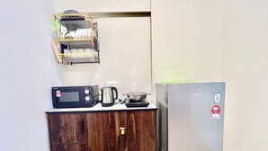 A kitchenette with a microwave, kettle, and a small refrigerator. - Sunway Geo Avenue Next to Medical Center Sunway University and Taylor University (Subang Jaya)
