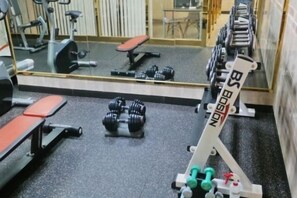 A gym with exercise equipment, including dumbbells and a bench. - HANGANG Gold Hotel Seoul (Seoul)