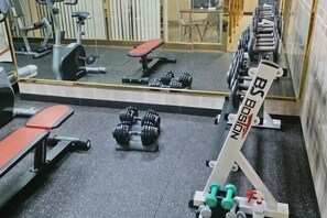 A gym with exercise equipment, benches, and a mirrored wall. - HANGANG Gold Hotel Seoul (Seoul)