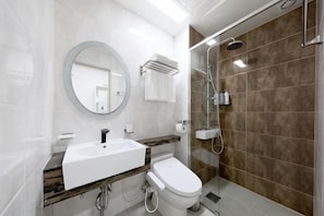 Baño con lavamanos, inodoro, espejo y ducha.