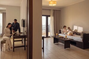 A hotel room with a dining table, a sofa, a coffee table, and a TV. - Steigenberger Aqua Magic, All Inclusive (Hurghada)