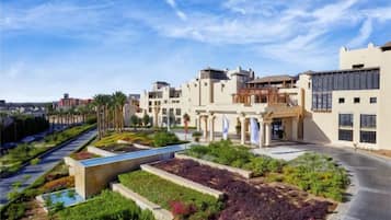 A hotel with a landscaped garden, a swimming pool, and a modern architectural design.