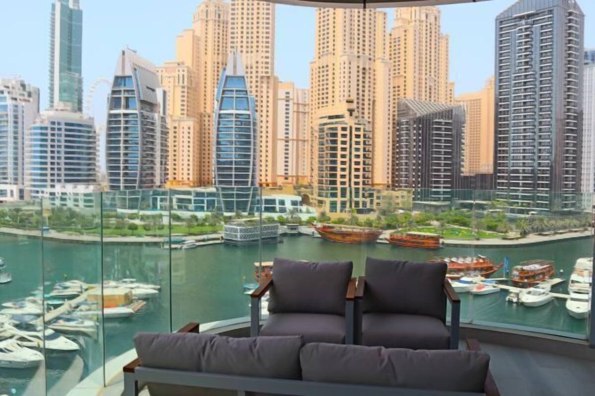 A high-rise building with a view of a marina and other buildings.