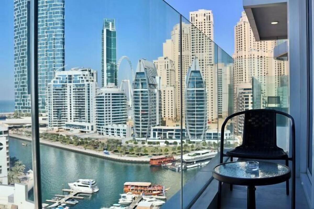 A high-rise building with a view of a marina and other buildings.