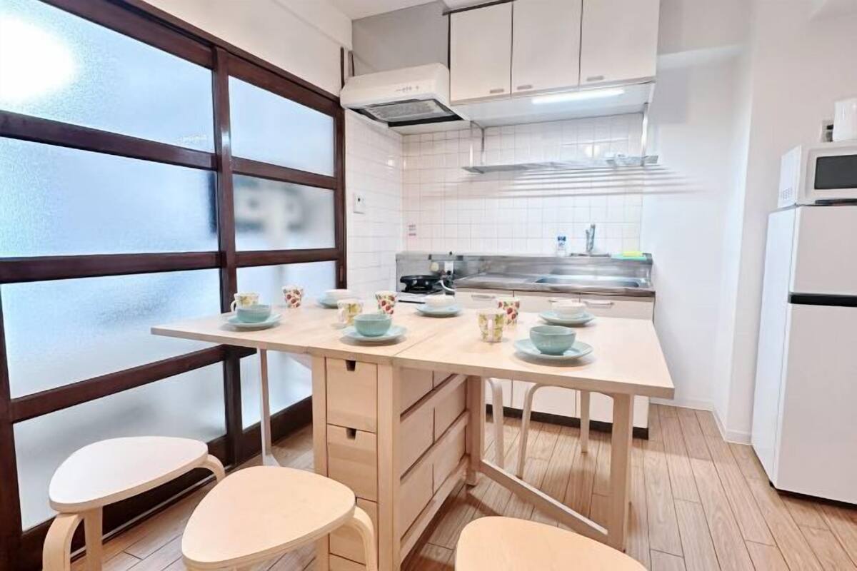A kitchen with a central island, white cabinets, a microwave, and a refrigerator.