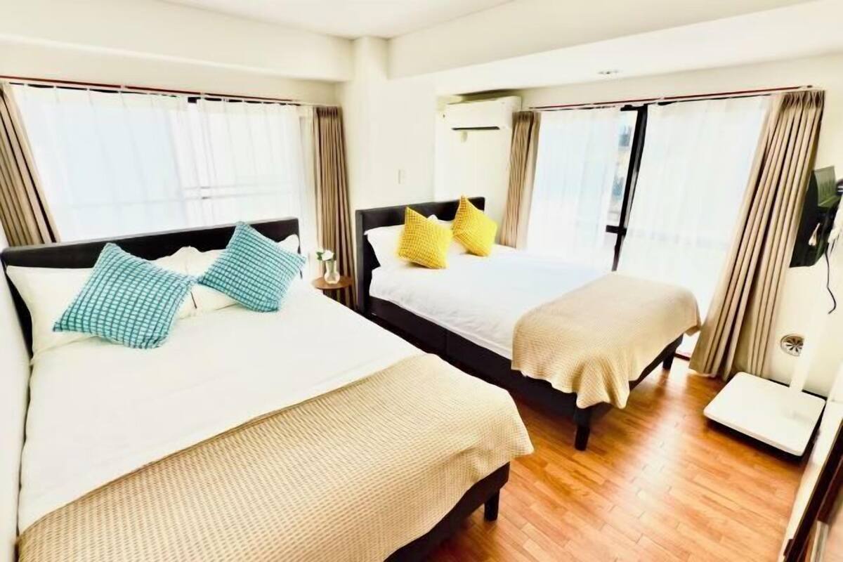 A hotel room with two beds, a scale, and a TV.