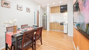 Una cucina moderna con mobili in legno, forno integrato e frigorifero in acciaio inossidabile.