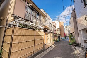 A narrow urban street with traditional buildings, a bamboo fence, and a clear sky. - daiwa Hotel, Skytree, Ueno Park, Asakusa Temple (Tokyo)