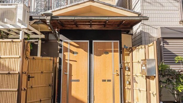 Un ingresso tradizionale giapponese con un cancello in legno e un tetto in tegole.