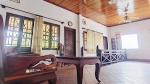 A spacious room with a wooden ceiling, a large table, and a bench. - Nan Ya Hotel(Sene Hua Phanh Guesthouse) (Luang Prabang)