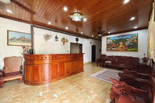 Un área de recepción con un mostrador de madera, un sofá y un cuadro en la pared.