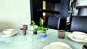 A dining table set with bowls, cups, and a potted plant.