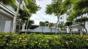 A modern building with a covered walkway and greenery.