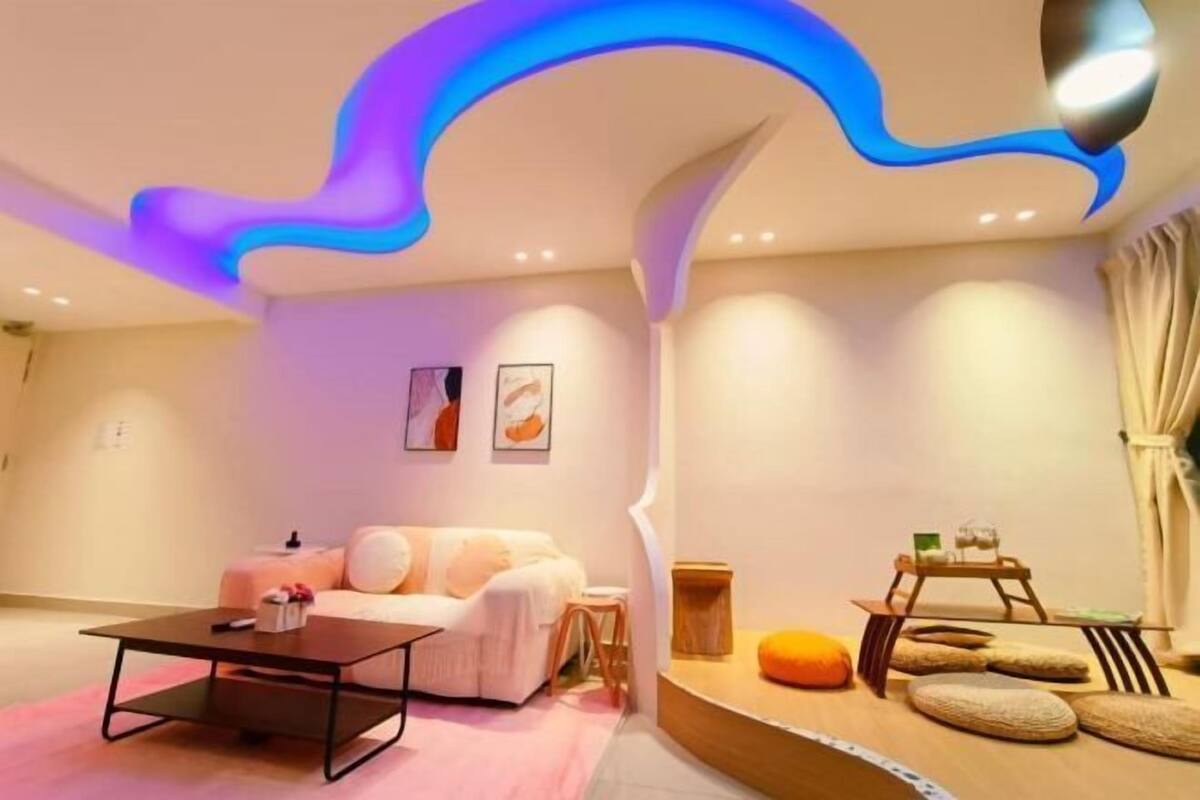 Ein modernes Wohnzimmer mit einer Couch, einem Couchtisch und einem einzigartigen Deckendesign.