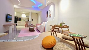 Una sala de estar moderna con sofá, mesa de centro y comedor con sillas y una mesa.