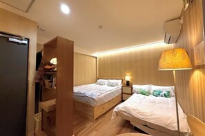 A hotel room with two beds, a wardrobe, a bedside table with a lamp, and a wall-mounted air conditioner. - Tokyo Star House-Skytree Homestay (Tokyo)