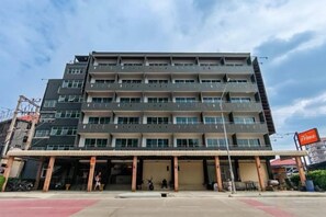 A multi-story building with a flat facade, a covered entrance area, and a visible signboard. - Prima Place South Pattaya (Pattaya)