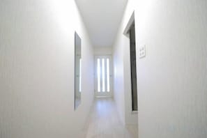 A narrow hallway with white walls and a wooden floor. - Northern Hills Minami 6 (Sapporo)