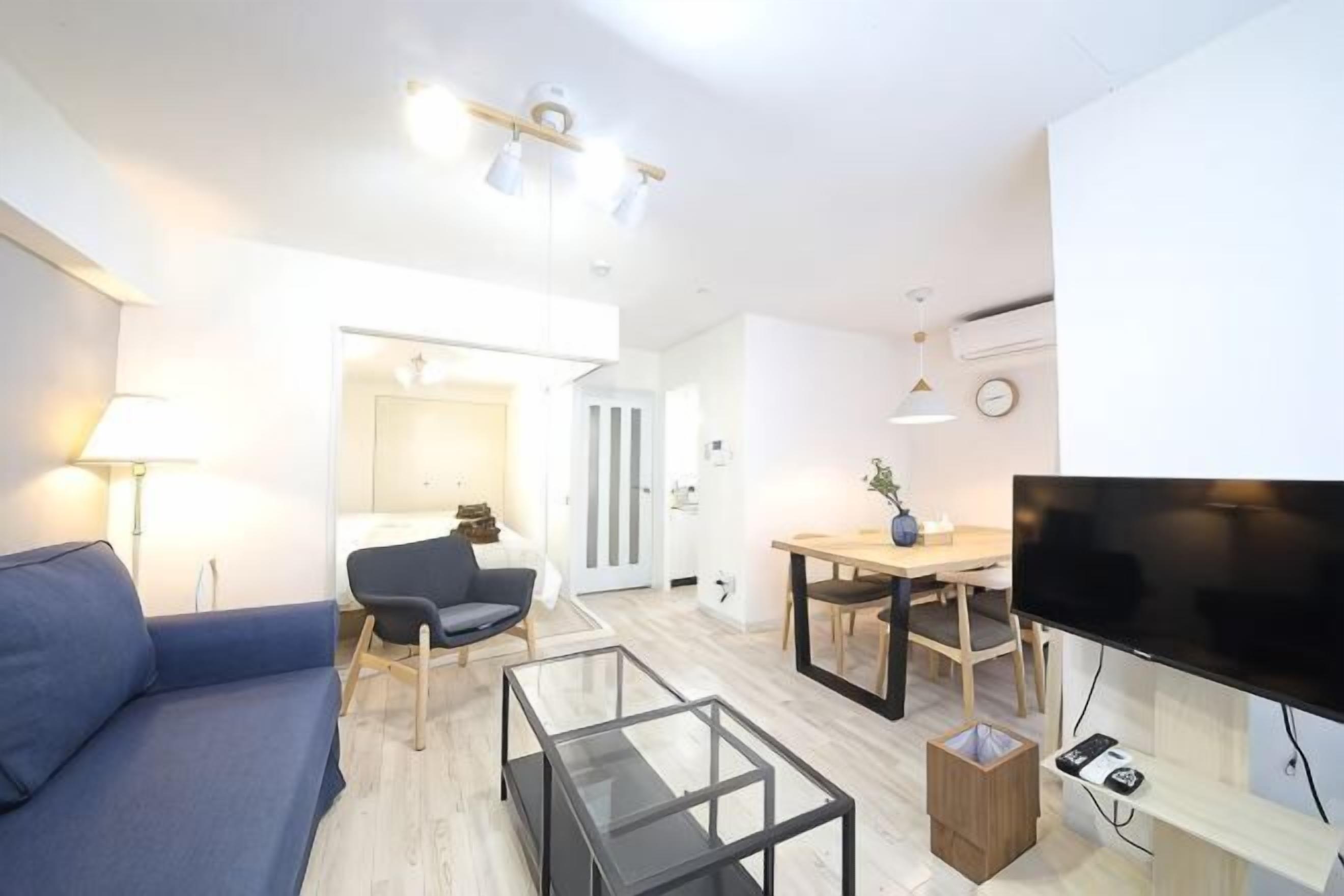 Una sala moderna con un sofá, una mesa de centro, un televisor y un comedor.