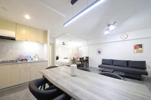 Una cocina moderna con comedor, un sofá y un reloj en la pared.