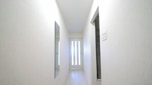 A narrow, well-lit hallway with white walls and a light wooden floor. - Northern Hills Minami 6 (Sapporo)