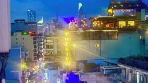A cityscape with illuminated buildings and a hotel with a sign that reads 'THE VIEW.' - Atusy Boutique Hotel (Ho Chi Minh City)