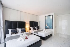 A modern hotel room with two beds, a large window, and a view of the city. - Your Days PLUS pool villa (Pattaya)