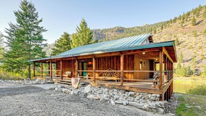 A rustic cabin with a metal roof, wooden exterior, and a porch with seating. - Hike, Fish & Unwind: Remote Escape in Montana (Saint Regis)